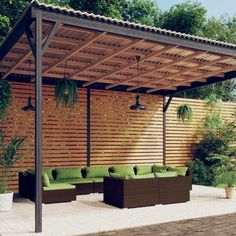 an outdoor living area with couches, tables and a pergolated wall in the background