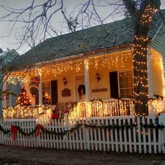 a white house covered in christmas lights and decorations