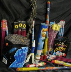 an assortment of school supplies are displayed on a black cloth background, including pens and pencils