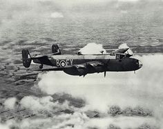 an old airplane flying in the sky above clouds