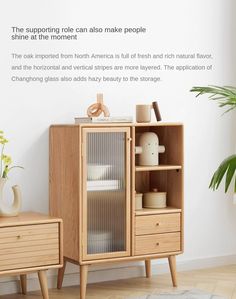 a wooden cabinet sitting next to a plant on top of a hard wood floored floor