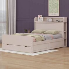 a white bed sitting on top of a hard wood floor next to a purple wall