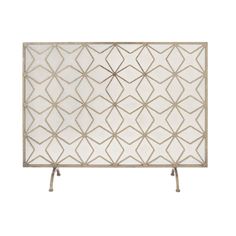 a white fireplace screen with an intricate design on the front and side panels, along with two metal legs