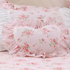 a bed with pink flowers and ruffles on it