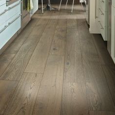 a kitchen with wooden floors and white cabinets