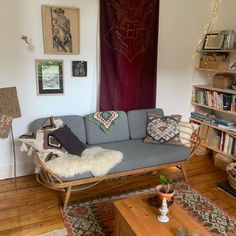 a living room filled with furniture and lots of books on the shelf next to it