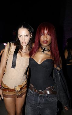 two women dressed in corsets and leathers posing for the camera at an event