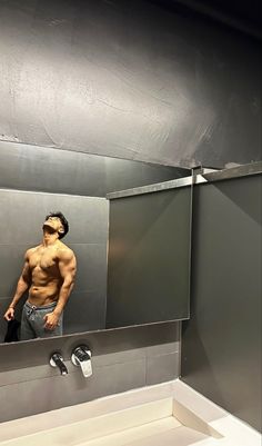 a man standing in front of a mirror with his shirt off and no shirt on