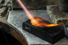 a close up of a piece of metal on a table with fire coming out of it