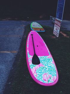 two surfboards sitting on the grass next to a street sign