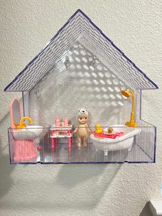 a plastic doll house with toys in it on the shelf and shelves above, along with other items