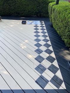 a black and white checkerboard pattern on a wooden deck