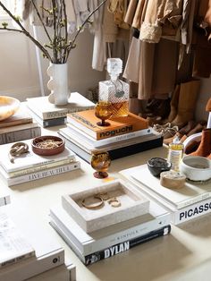 a table topped with lots of books and vases filled with different types of jewelry