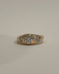 a three stone diamond ring on a white surface