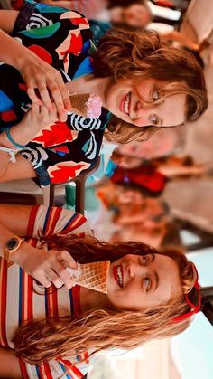 two young women standing next to each other in front of a table with an ice cream cone