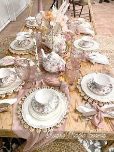 the table is set with pink and white china