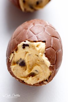 two chocolate eggs with ice cream inside on a white surface