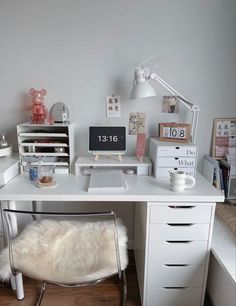 a white desk topped with a computer and lots of drawers