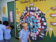 two children are standing in front of a bulletin board