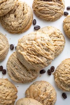 chocolate chip cookies and coffee beans are arranged on a white surface with the cookie being frosted