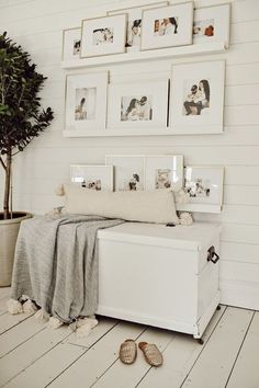 a white bedroom with pictures on the wall