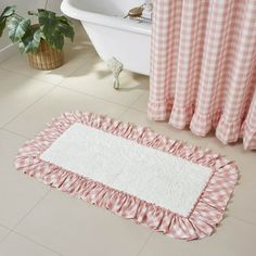 a pink and white checkered bath mat on the floor