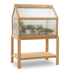 a wooden shelf with a glass top and shelves below it, holding plants in pots