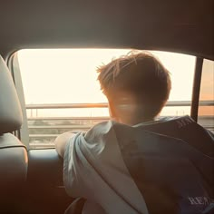 a man sitting in the back seat of a car with his head turned to the side