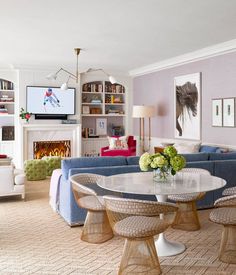 a living room filled with furniture and a flat screen tv mounted on the wall above a fireplace