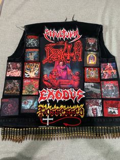 the back of a black vest with many pictures on it