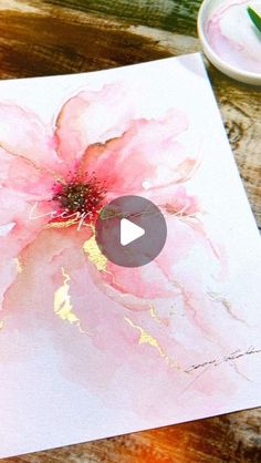 a pink flower is being painted on paper