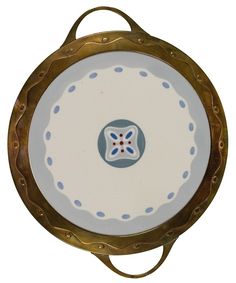 a white and blue plate sitting on top of a wooden stand with gold trimming