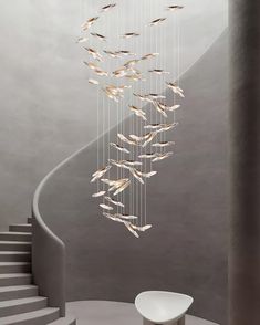 an artistic chandelier hanging from a spiral staircase