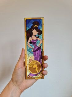 a hand holding up a stained glass card with an image of a woman on it