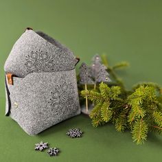 a pair of face masks sitting on top of a green surface next to pine branches