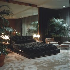 a large bed sitting in the middle of a living room next to a plant filled wall