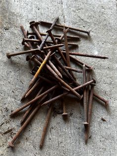 a pile of nails sitting on top of a cement floor