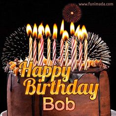 a birthday cake with lit candles and the words happy birthday bob on it's side