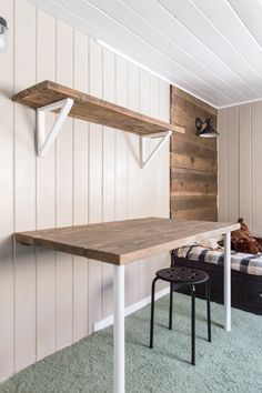 a room with a desk and some shelves on the wall next to a bed that is made out of wood