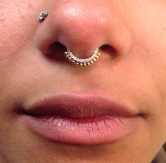 a close up of a person's nose with a nose ring on top of their nose