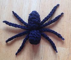 a blue spider sitting on top of a wooden table