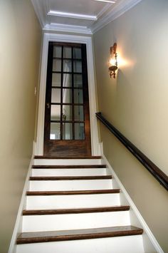 an empty hallway with stairs leading up to the door