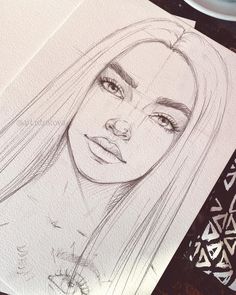 a pencil drawing of a woman's face with long hair and blue eyes on paper