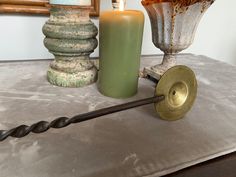 a candle is sitting on top of a table next to some decorative objects and candles