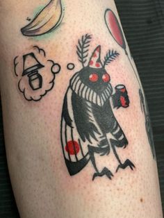 a tattoo on the leg of a person with a bird and other items around it