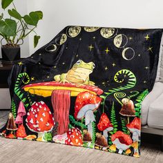 a blanket with a frog sitting on top of a mushroom covered in mushrooms and stars