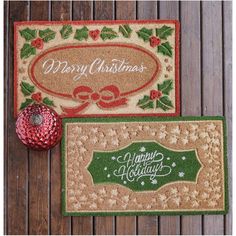 two christmas doormats on a wooden floor with a red ornament next to them