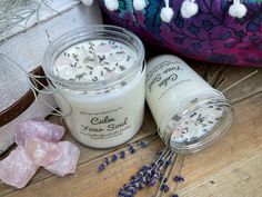 two jars filled with lavender on top of a wooden table