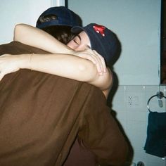 two people hugging each other in the bathroom