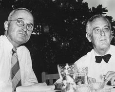 two men sitting at a table with glasses on